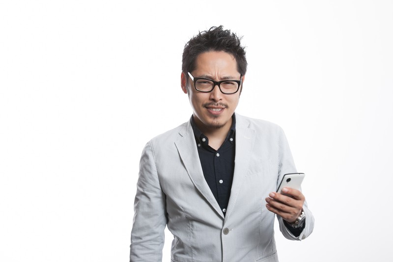 スマホを片手に持つ男性